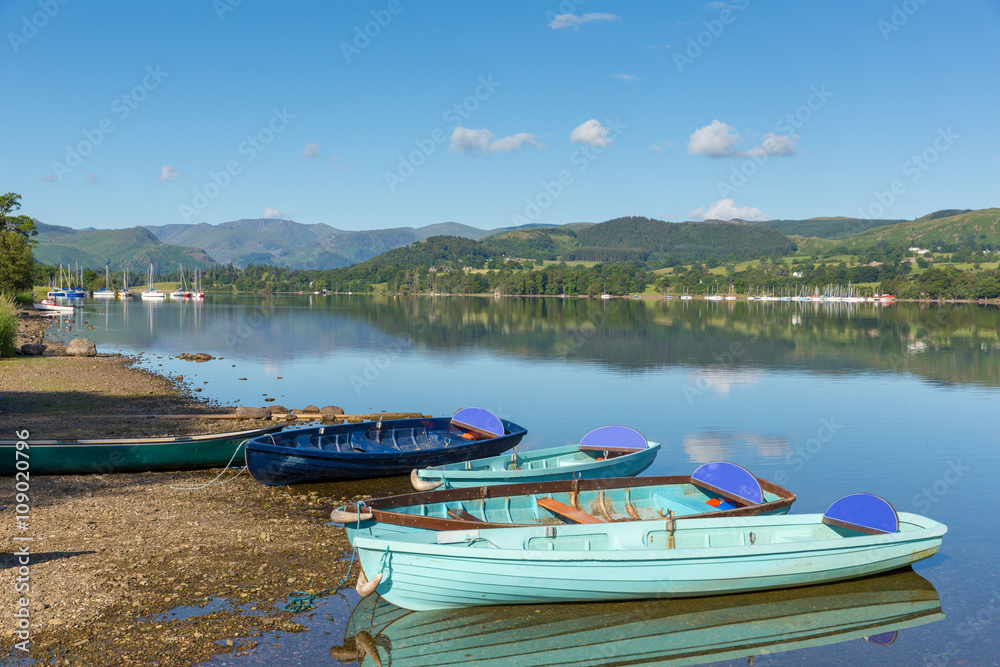 Fototapeta premium Rowing boats for hire for pleasure and leisure by beautiful lake and mountains calm still day