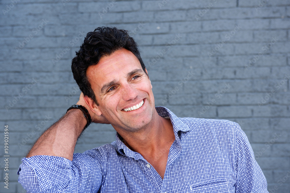 Close up handsome man smiling with hand in hair Close up handsome man smiling with hand in hair