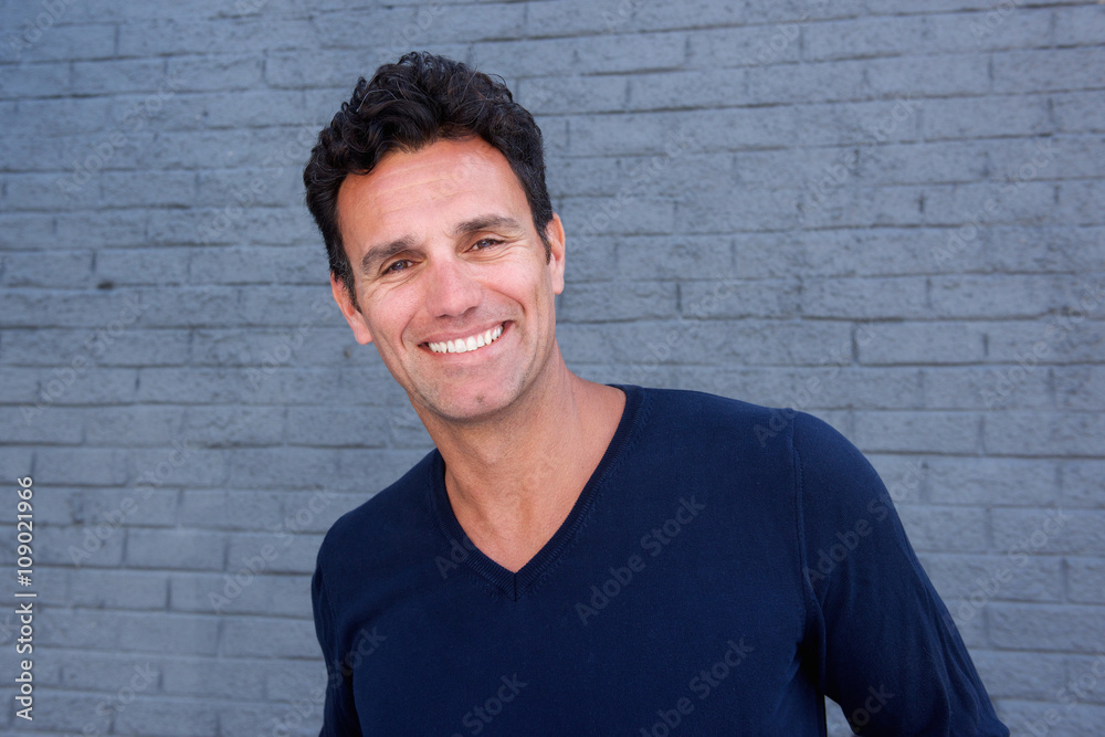 Close up handsome guy smiling against gray wall Close up handsome guy smiling against gray wall