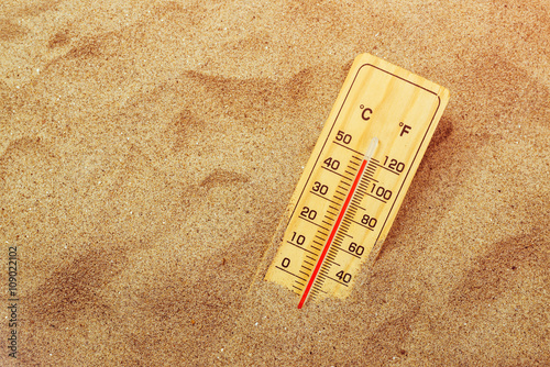 Thermometer on warm desert sand photo