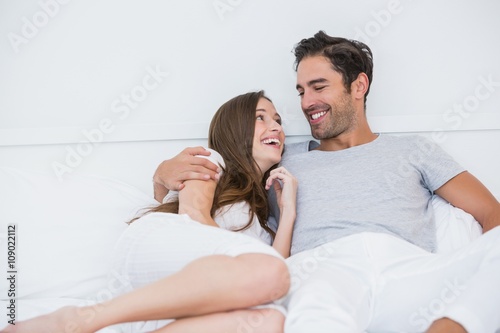 Happy couple relaxing on bed 