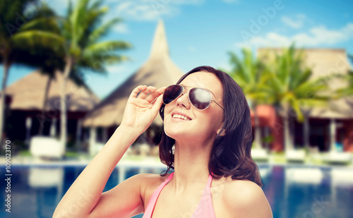 happy woman in sunglasses and swimsuit on beach