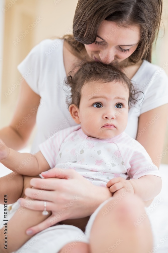 Mother kissing daughter while sitting at home Mother kissing daughter while sitting at home