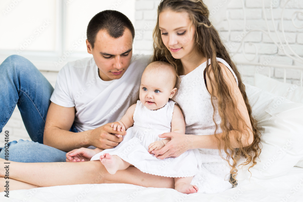Mother and father with little baby in a bed Mother and father with little baby in a bed