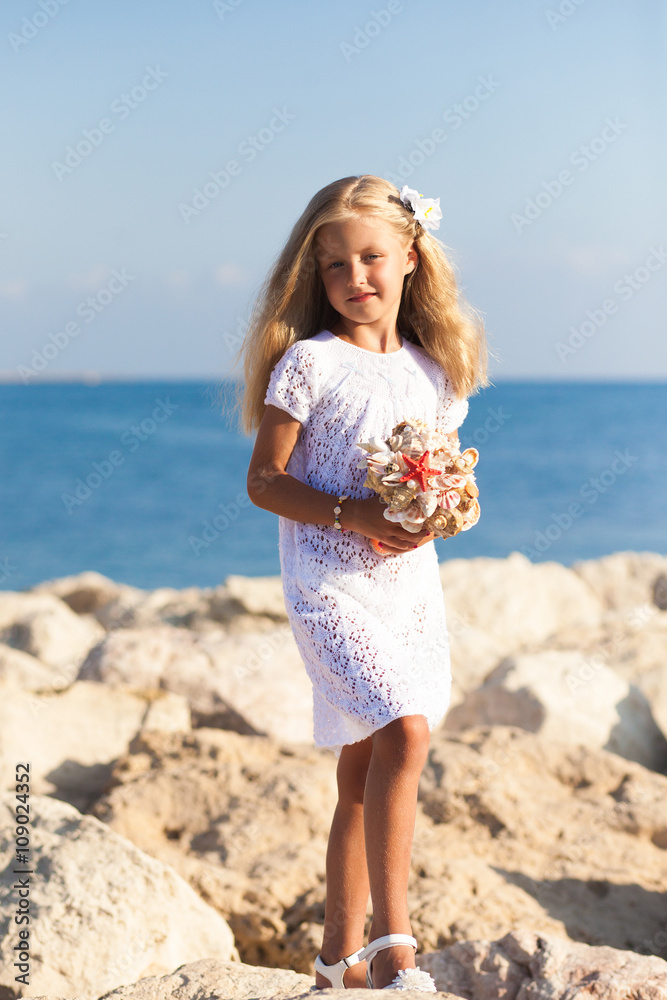 Beautiful girl standing on rocky seashore Beautiful girl standing on rocky seashore
