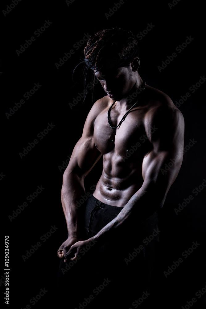 Black muscular man on a black background Black muscular man on a black background