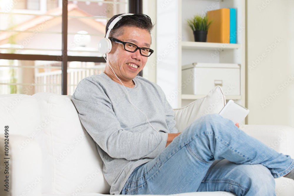 Asian senior relaxing with entertainment on tablet. Asian senior relaxing with entertainment on tablet.