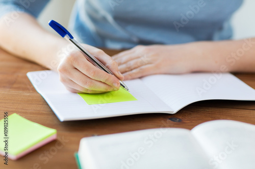 close up of student with book and notebook at home