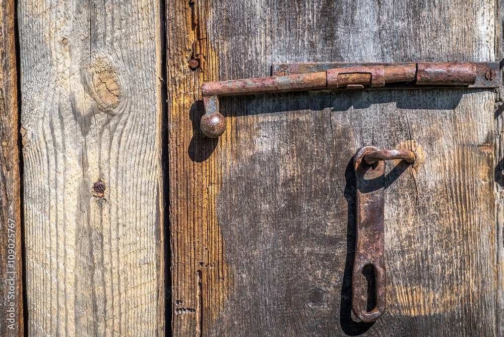old wooden door with an iron bolt old wooden door with an iron bolt