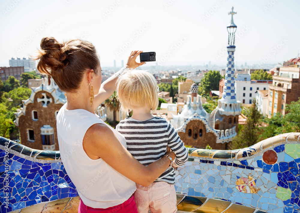 Naklejka premium Matka i dziecko robią zdjęcia aparatem cyfrowym w Park Guell