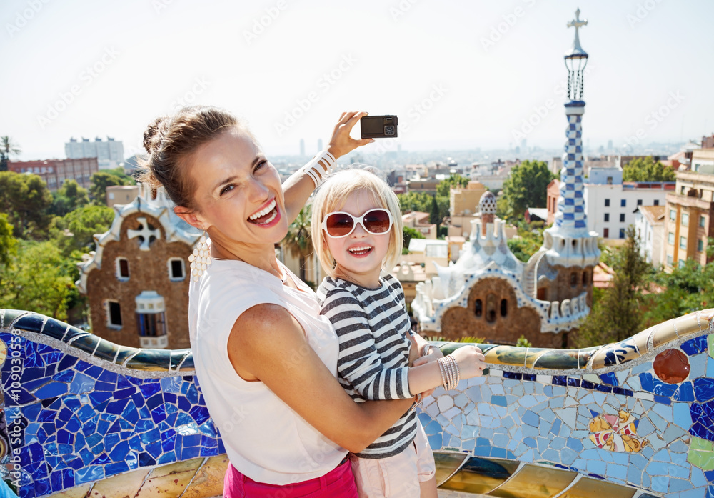 Fototapeta premium Uśmiechnięta matka i dziecko robienia zdjęć aparatem w Park Guell