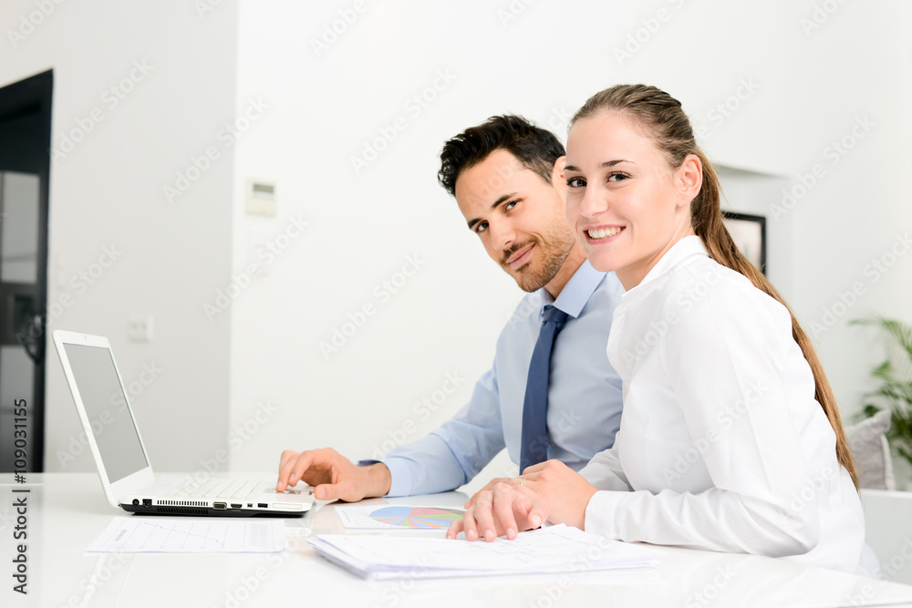 business people man and woman working together with a laptop computer in office business people man and woman working together with a laptop computer in office