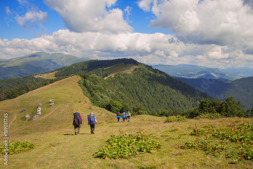 Group of hikers walking on trail. Men and women go with  backpac © alter_photo