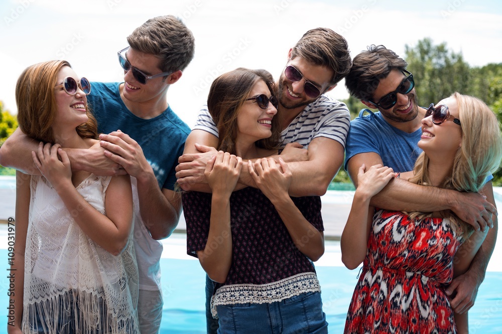 Three men embracing women near pool Three men embracing women near pool