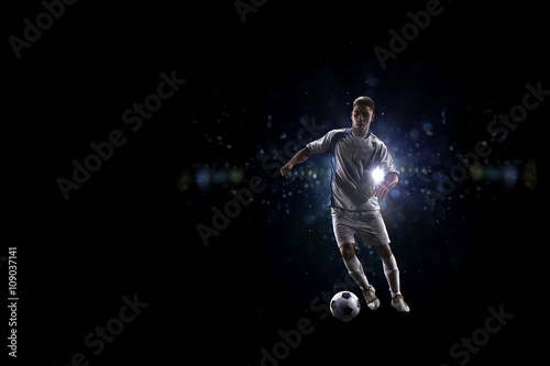 Soccer player in action over black background © 103tnn