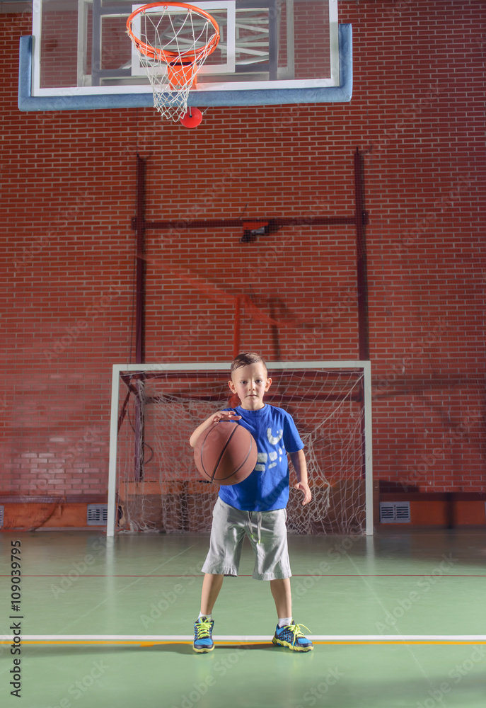 Sporty little boy playing basketball