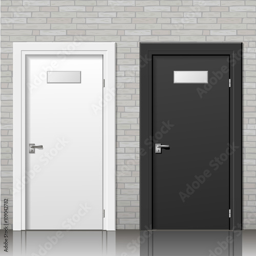 Black and white door with signs on an old brick wall