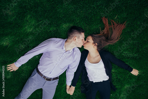 Lovely couple liying on the grass and smile photo