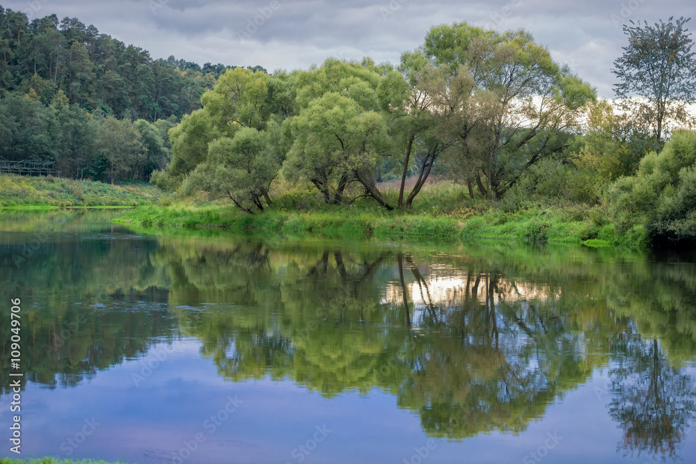 Wide river in green banks overgrown with woods Wide river in green banks overgrown with woods