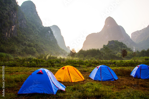 Looming karst formations with tents underneath in Yangshuo, China.