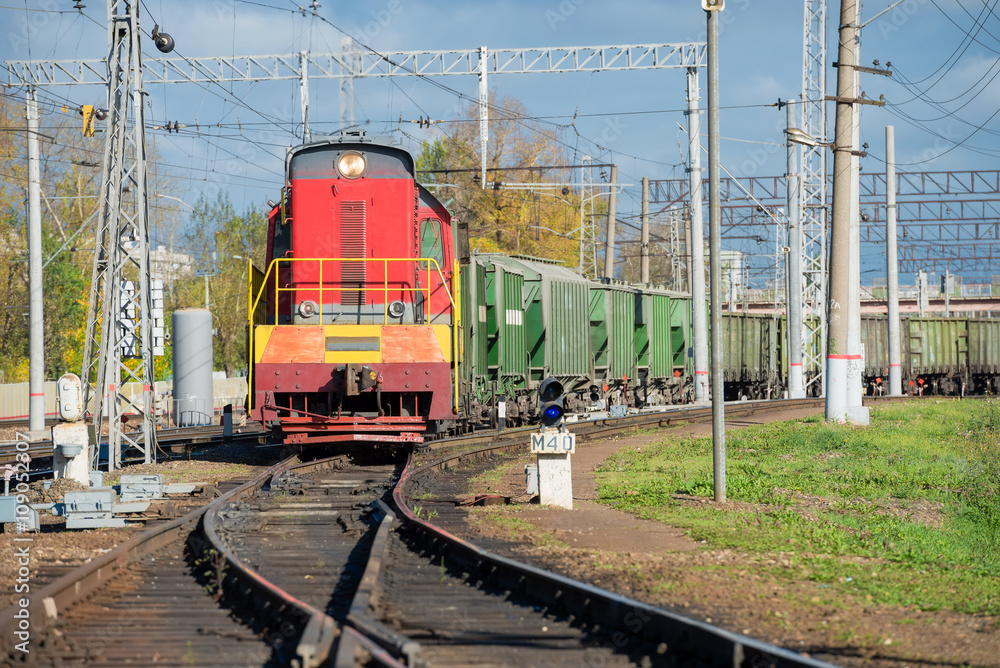 Red locomotive and Green freight cars on the rails Red locomotive and Green freight cars on the rails