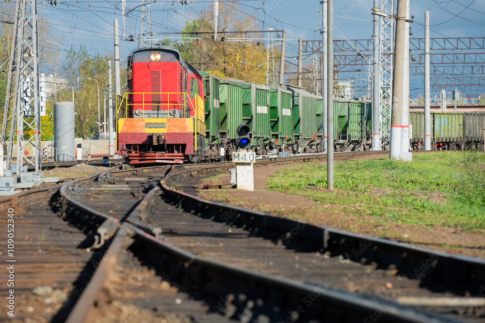 Red locomotive and Green freight cars on the rails Red locomotive and Green freight cars on the rails