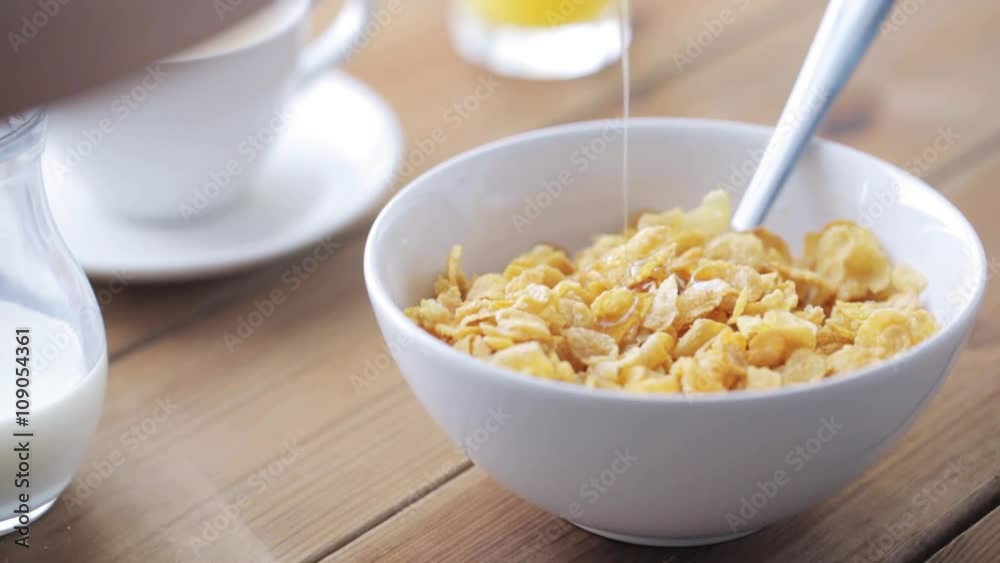 honey pouring to corn flakes on wooden table