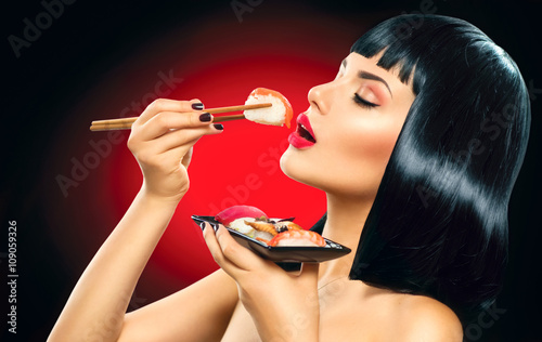 Sushi. Fashion art portrait of beauty model girl eating sushi