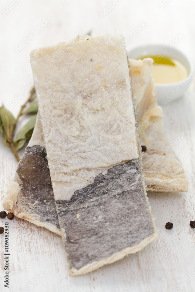 dry salted cod fish on white wooden background