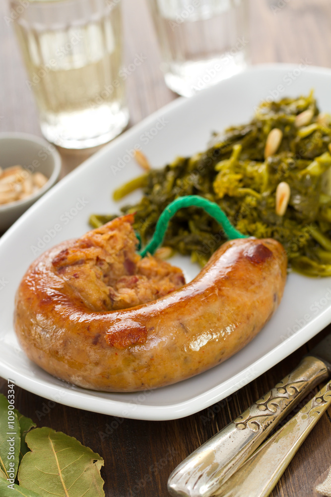 traditional portuguese smoked sausage with turnip greens on white plate