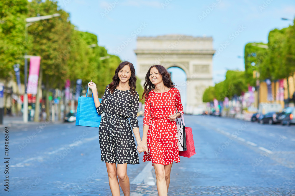 Happy twin sisters doing shopping on holidays in France