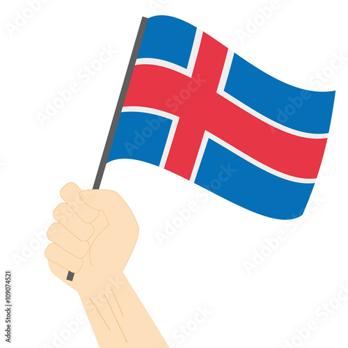 Hand holding and raising the national flag of Iceland
