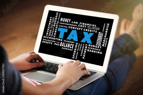 Tax concept. Woman sitting on the floor and working with a laptop