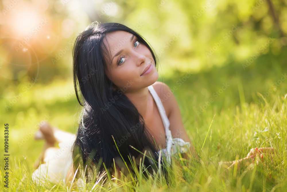 The young girl lies on a forest glade in a sunny day The young girl lies on a forest glade in a sunny day