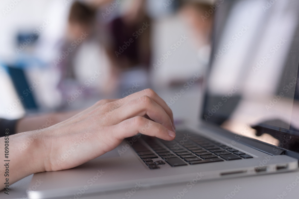 close up of business womans hand typing on laptop with team on m close up of business womans hand typing on laptop with team on m