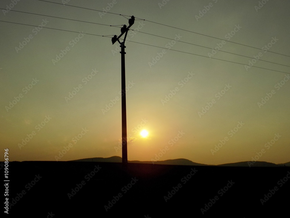 Power line column and sunset