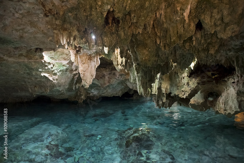 Inside of stone cave with blue water and rocks © cienpies