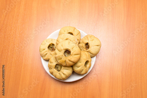 Vak belyash - bashkir national cuisine, homemade meat pies in white plate over wooden background,centered  photo