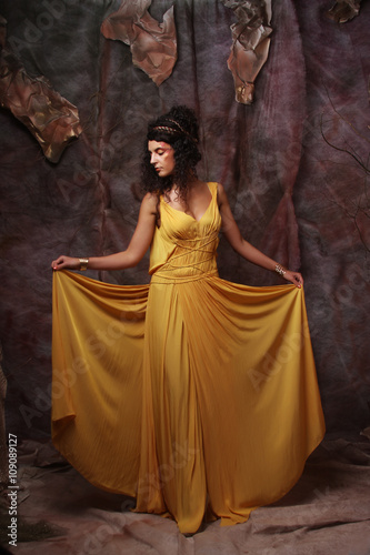 brunette woman wearing yellow evening dress © Raisa Kanareva