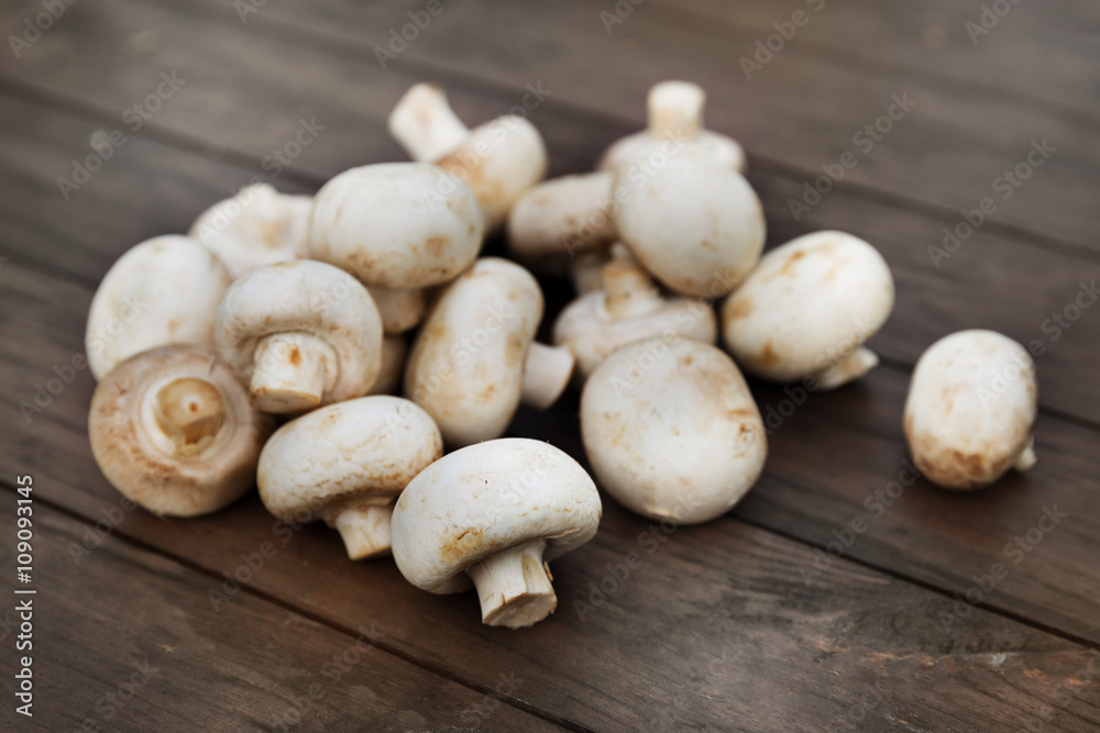 Fresh champignon mushhrooms on a wooden background Fresh champignon mushhrooms on a wooden background