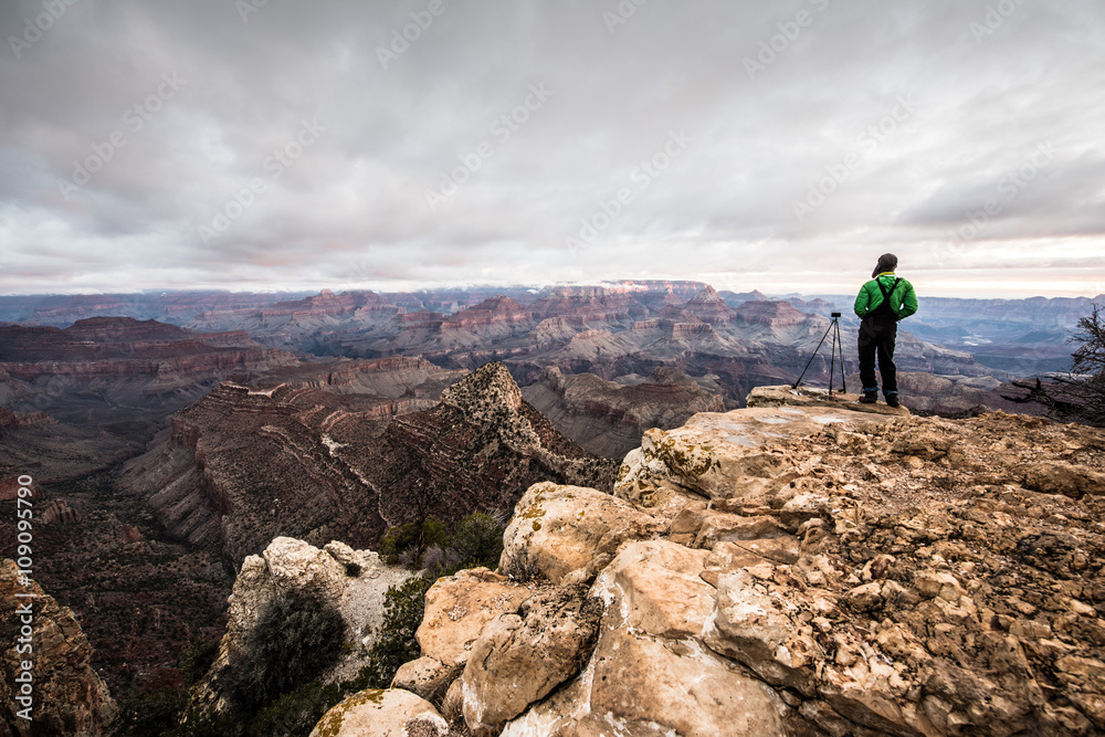 A man is standing at Grand Canyon for sunrise