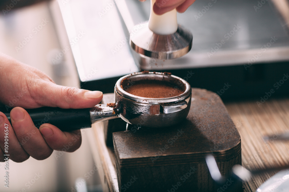 Barista pressing coffee in the machine holder Barista pressing coffee in the machine holder