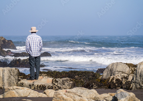 Matanzas, Chile - January 17, 2016 : Unidentified man watching the waves in Pacific ocean, documentary editorial. photo