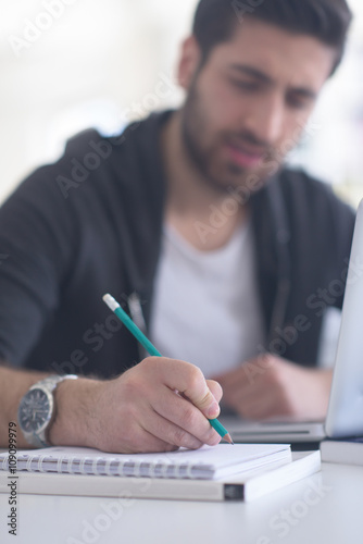 student in school library using laptop for research