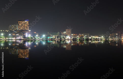 Cityscape of Pattaya beach at night with water reflection