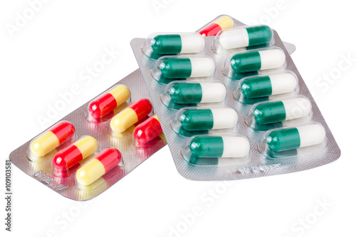 two packages with red green yellow pills on white background