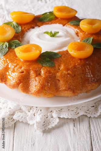 French Savarin cake decorated with apricots and mint close-up. vertical 