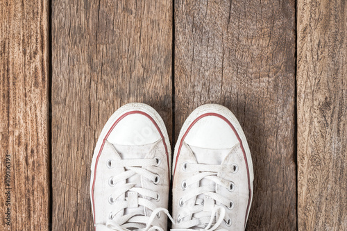 White sneakers from an aerial view on wooden floors. Top view. © itim2101