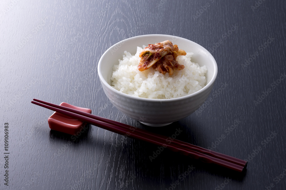 黒木目背景の白菜のキムチとごはんと箸 黒木目背景の白菜のキムチとごはんと箸