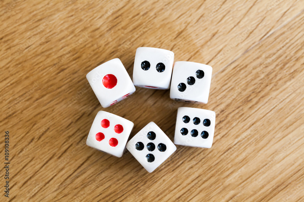 Photo of six white dices being rolled on wooden background Photo of six white dices being rolled on wooden background